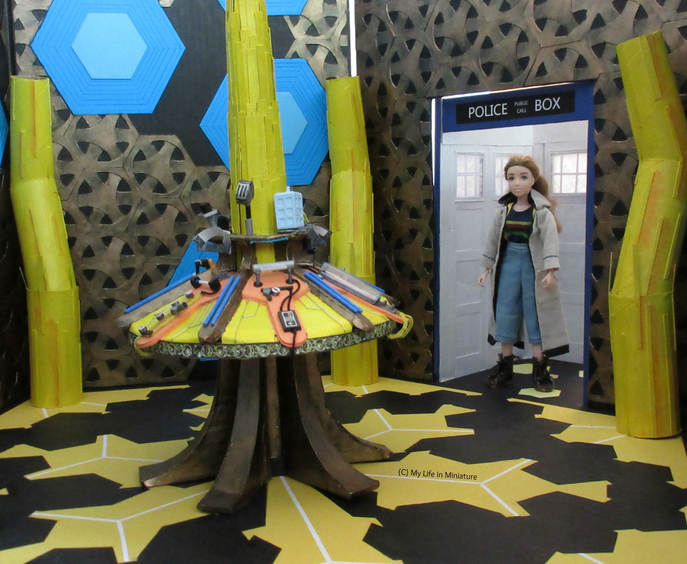 Sarah stands in the entryway of the TARDIS in Thirteenth Doctor cosplay, looking at the central console. Shot is taken at eye level.