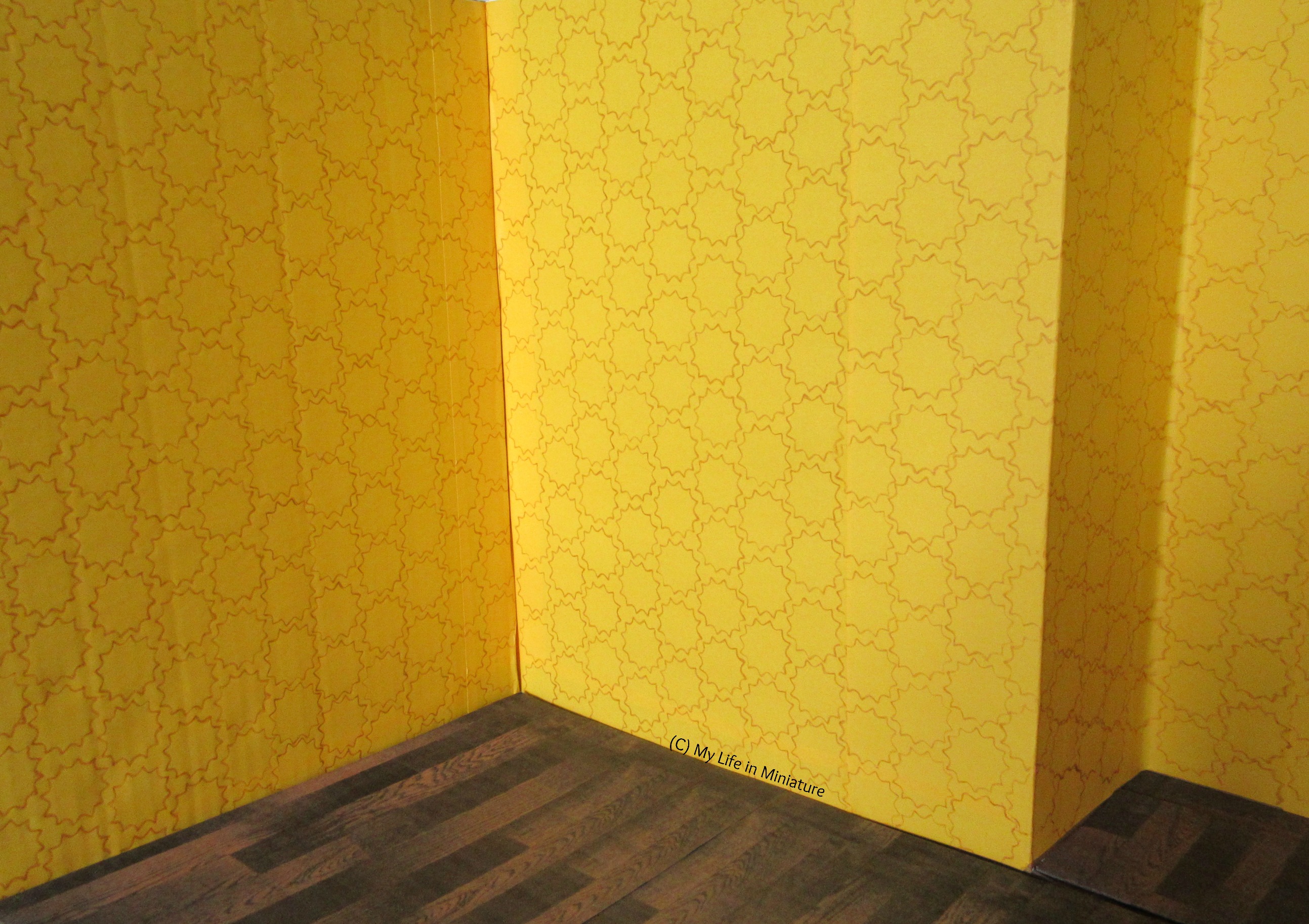 Shot of the interior of the store, yellow walls completely covered in stencilling. 