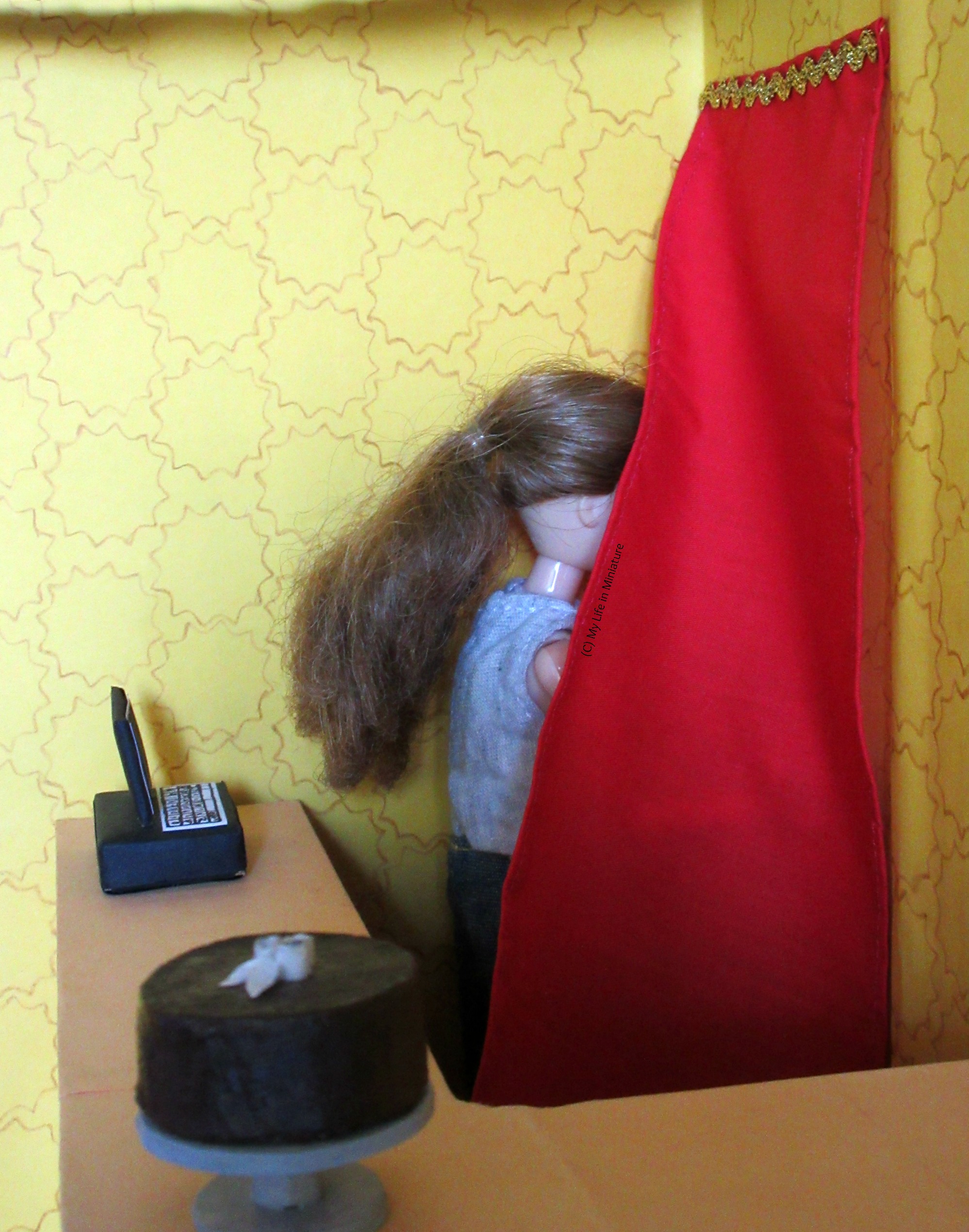 Sarah is holding the red curtain aside to go through it to the back rooms of Tea at Yaz's. The curved counter's top is visible in the foreground. 
