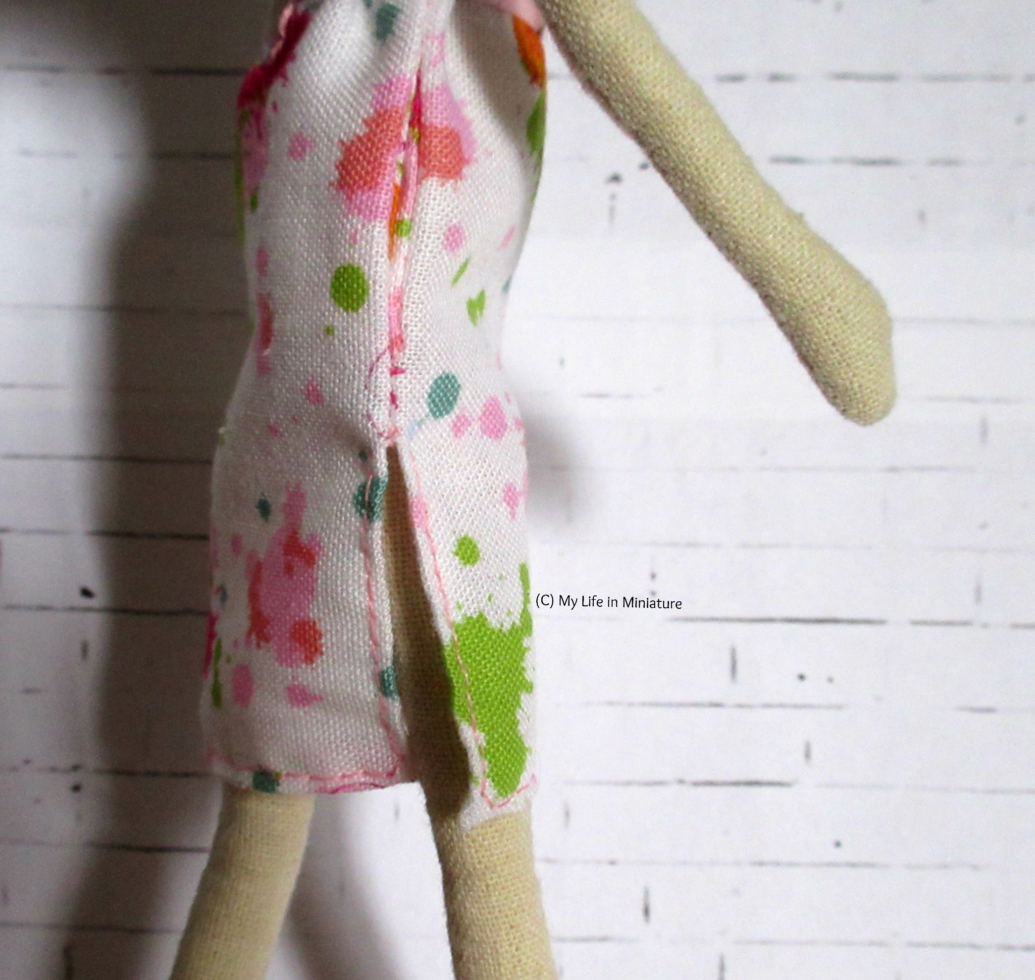 Close-up of the side of Lola's dress. Below the pockets on both side seams are slits so the doll can move. 