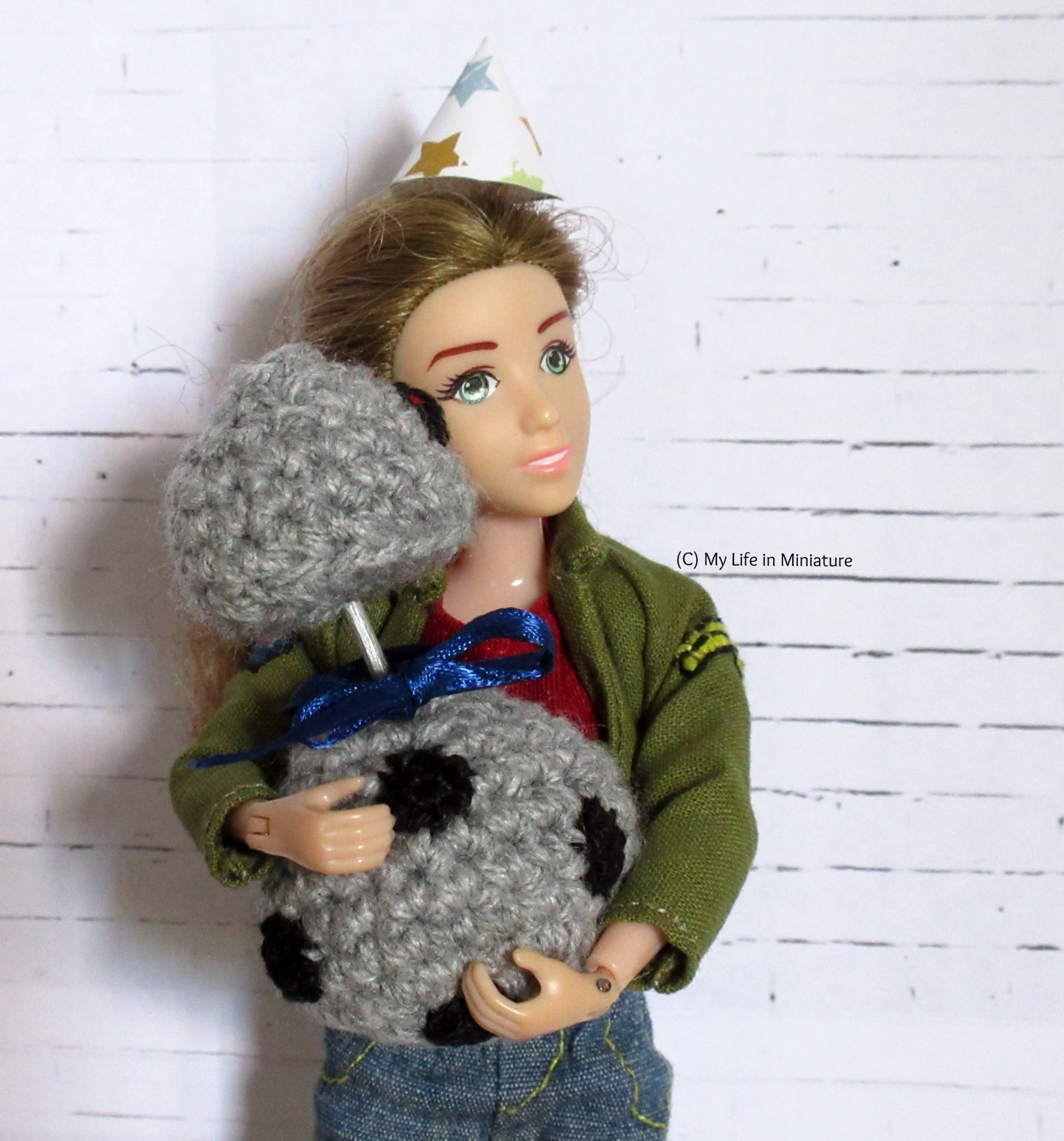 Sarah holds Chip in her arms, party hat on, as Chip holds their head next to Sarah's cheek. Sarah's grinning. 