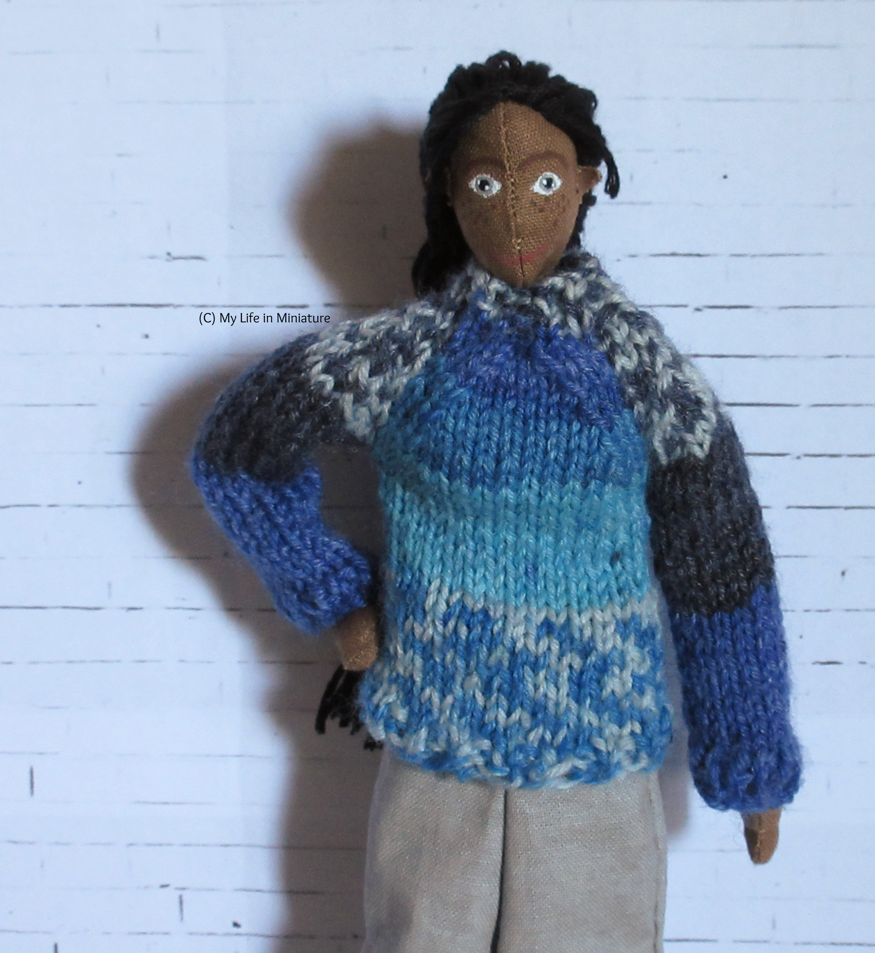 Petra looks at the camera, one hand on her hip. She's wearing the blue jumper. 