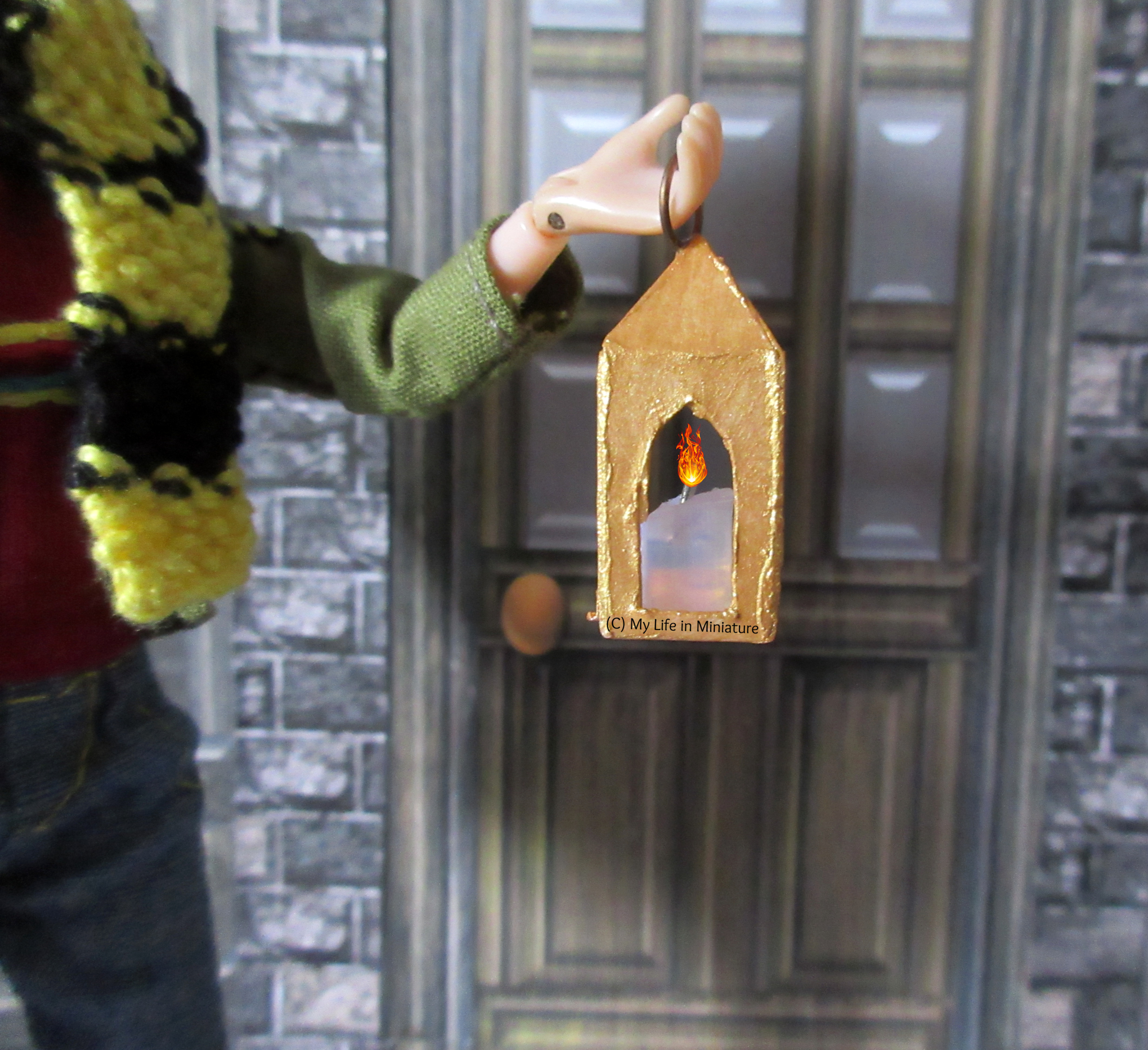 Close-up of the square lantern Sarah's holding. The candle inside looks like it's lit. 