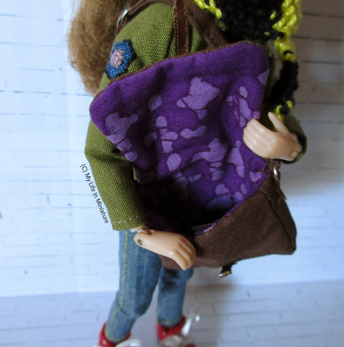 Sarah holds the bag open, as it's over her shoulder. The inside of the bag (and flap) is lined with purple batik fabric. 