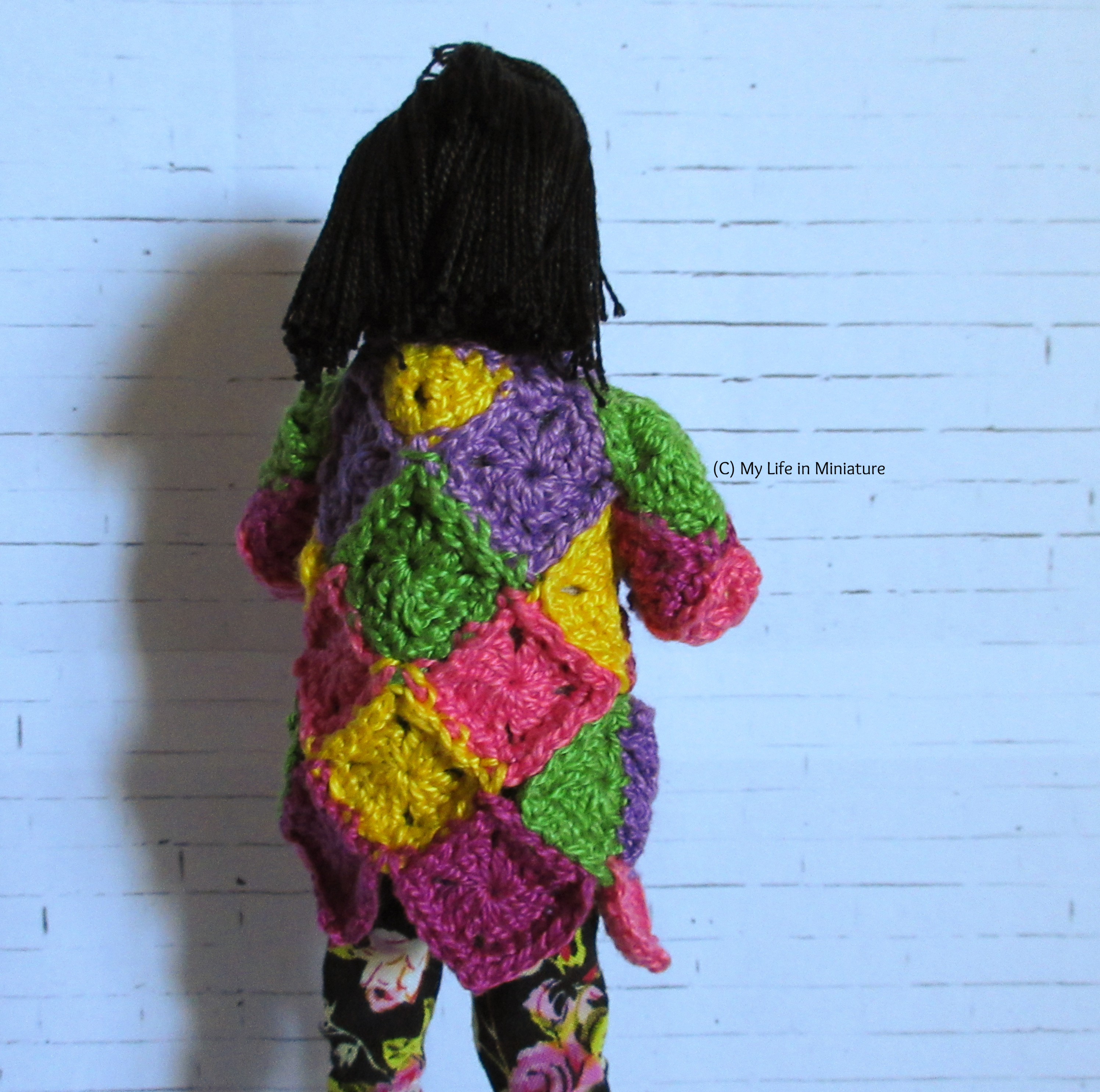 Tiffany faces away from the camera, showing the back of the cardigan.