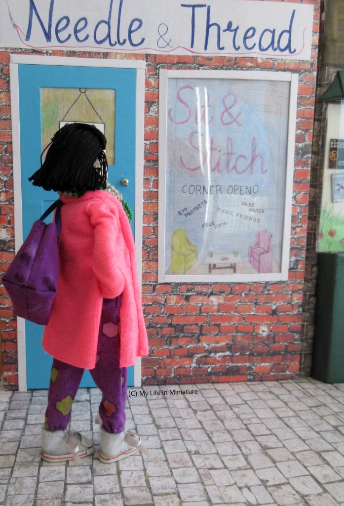 Tiffany stands outside Needle & Thread, looking away from the camera at the storefront.
