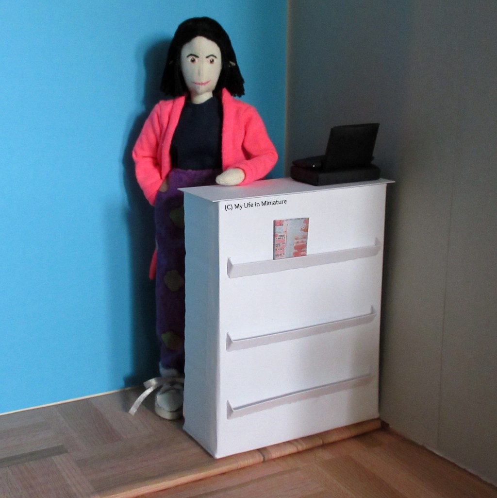 Tiffany stands behind the Needle & Thread counter, one elbow leaning on it.