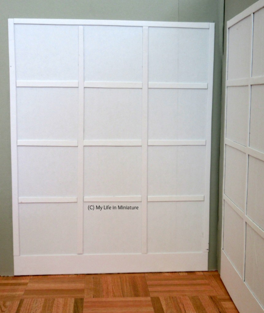 Image shows the left-hand cabinet from the first image. It is white and has twelve square shelves.