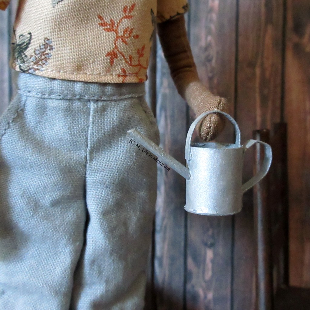 Petra holds the watering can at hip level.