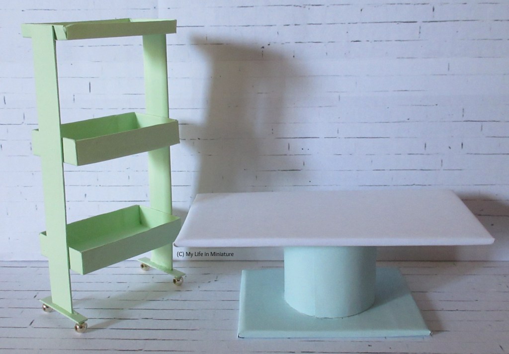 A pale green trolley with three trays is on the left. It's beside a coffee table with a white top and a pale blue base. 