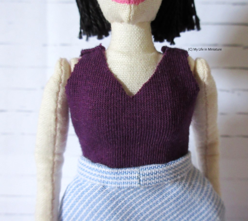 Tiffany wears the dark purple jersey top with her white-and-blue striped skirt.