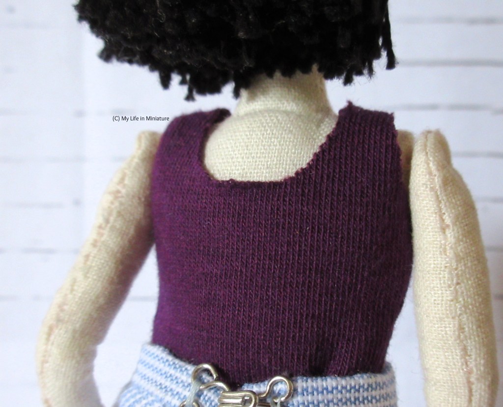 Back view of Tiffany's torso, showing the rounded back neck edge of the purple top.