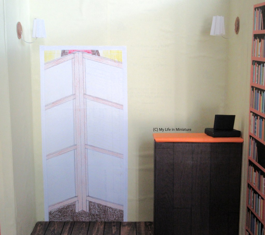 The 'counter nook' of the Palace Library is visible. To the right is the counter with a cash register on. To the left on the wall is a doorway with a room divider across it. Above the doorway and counter on the walls are two Victorian-esque lights.
