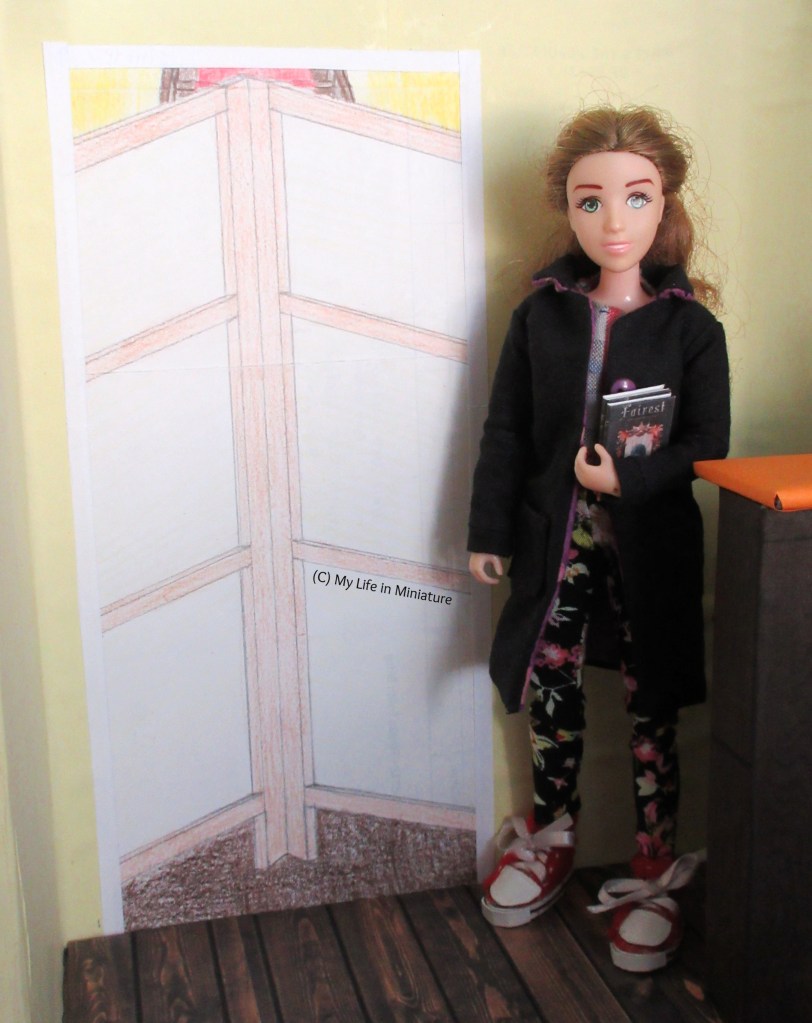 Sarah stands next to the doorway with the room divider across it. She wears a black coat with purple buttons, a blue shirt underneath, black floral pants, and red shoes. She has two books in her arm, and smiles at the camera. 