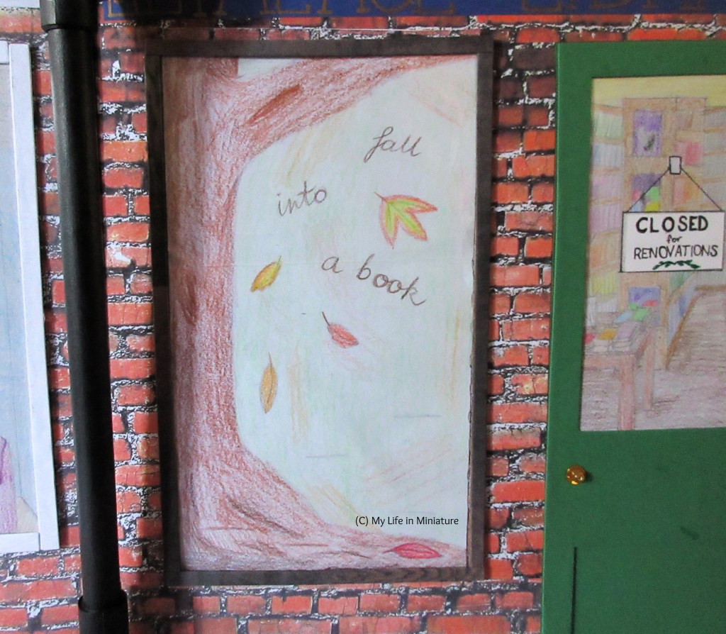 The front window of The Palace Library is visible. An autumnal display is visible, with a tree trunk, falling leaves, and the text 'fall into a book'.