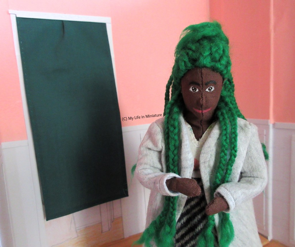 Hazel stands in Fierro's Bakery, facing the camera. She looks at her hands as she lists things that need doing on her fingers. Behind her is the green-curtained doorway. 