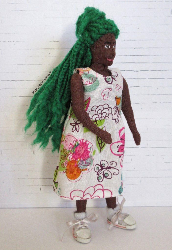 Hazel stands in front of a white brick background. She is turning towards the right of the frame on the spot, to make the skirt lift in a princess-esque twirl. Her hair swings in unison with the motion.