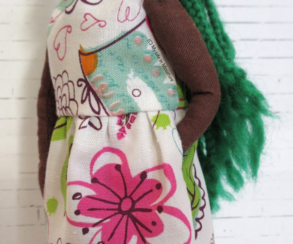 Close-up of the side seam of Hazel's white floral dress. Hazel's hand is in an in-seam pocket, so only her forearm and above is visible. 