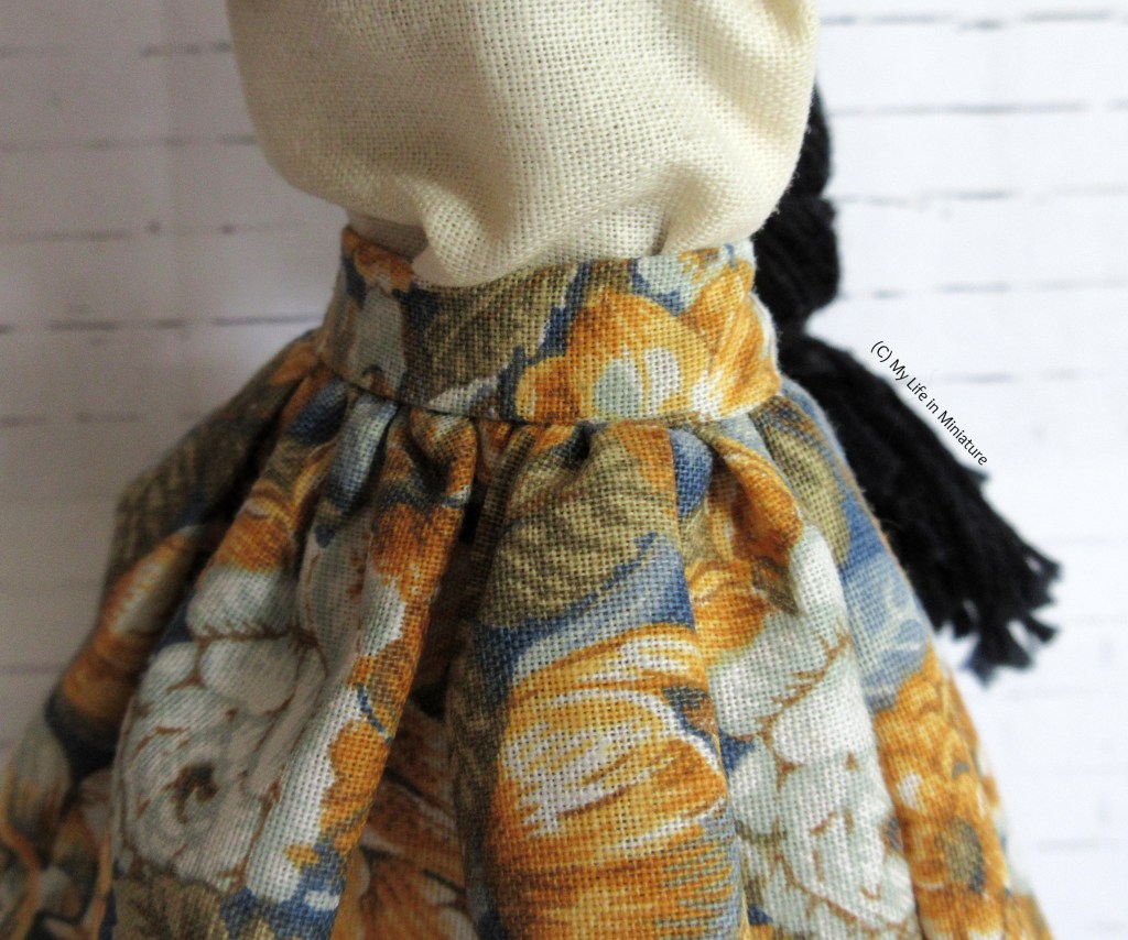 Close-up of the skirt's solid waistband and side seam, in which is a pocket opening that isn't visible. The skirt is very pouffy.