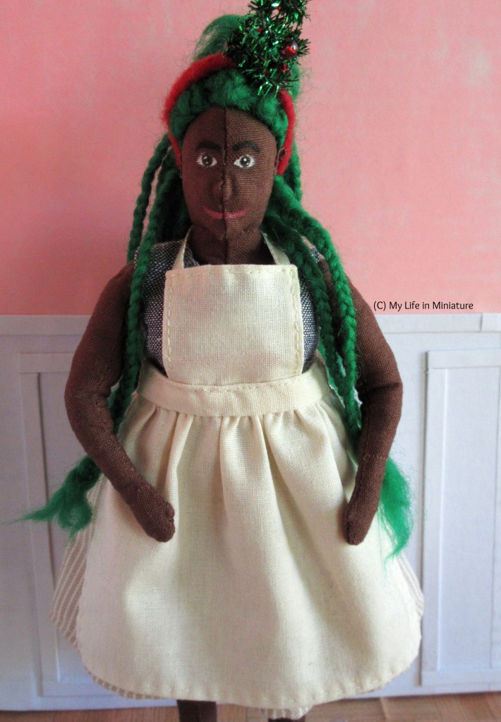 Hazel stands inside Fierro's, white-and-pink walls behind her. She faces the camera, smiling at it as she brushes her apron down with her hands. 