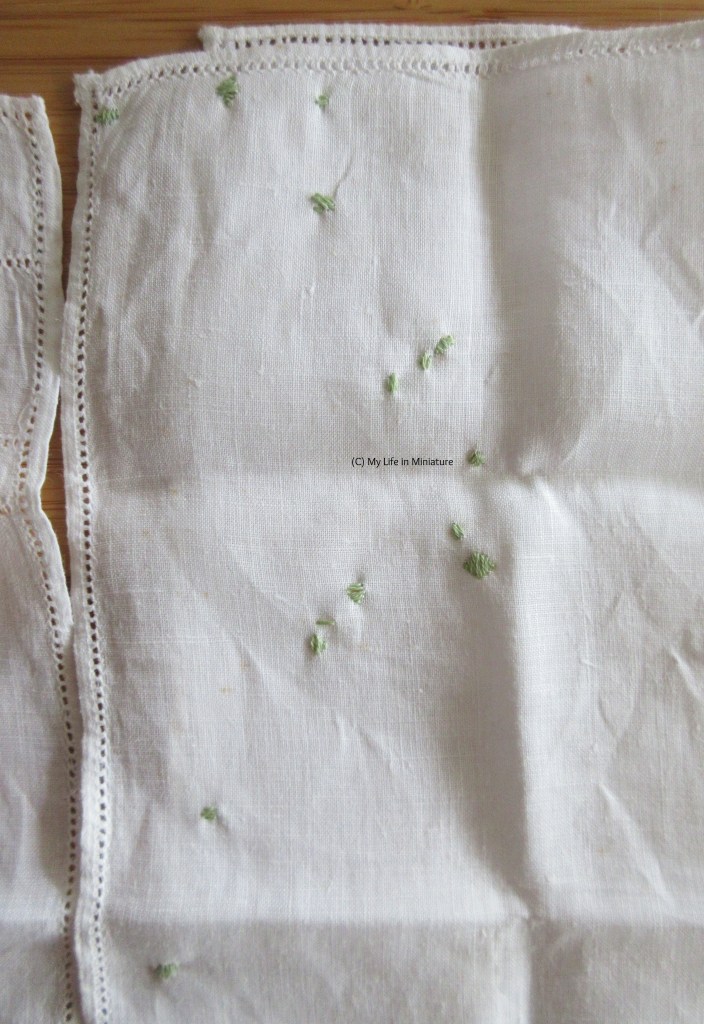 Close-up of one of the denser patches of green leaves. Each is embroidered over a brown stain. Some leaves are only three stitches, others are a bit more substantial. 
