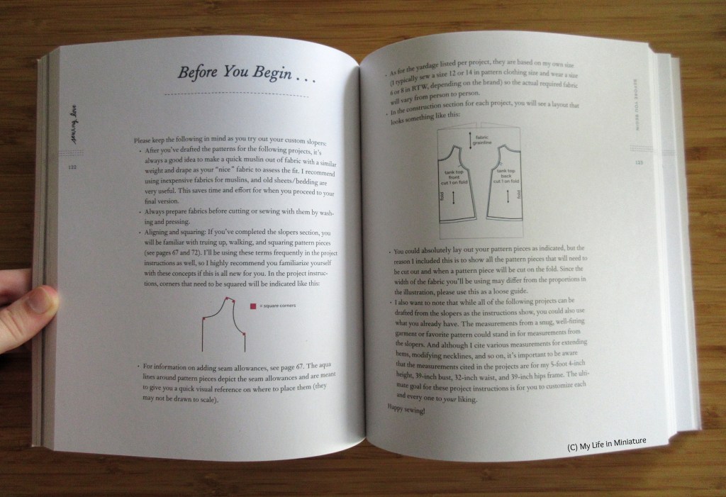 'Sewing Love', laid on a wood surface, held open to one of the interior pages. Most of it is text, but there are some diagrams of a basic torso pattern too.