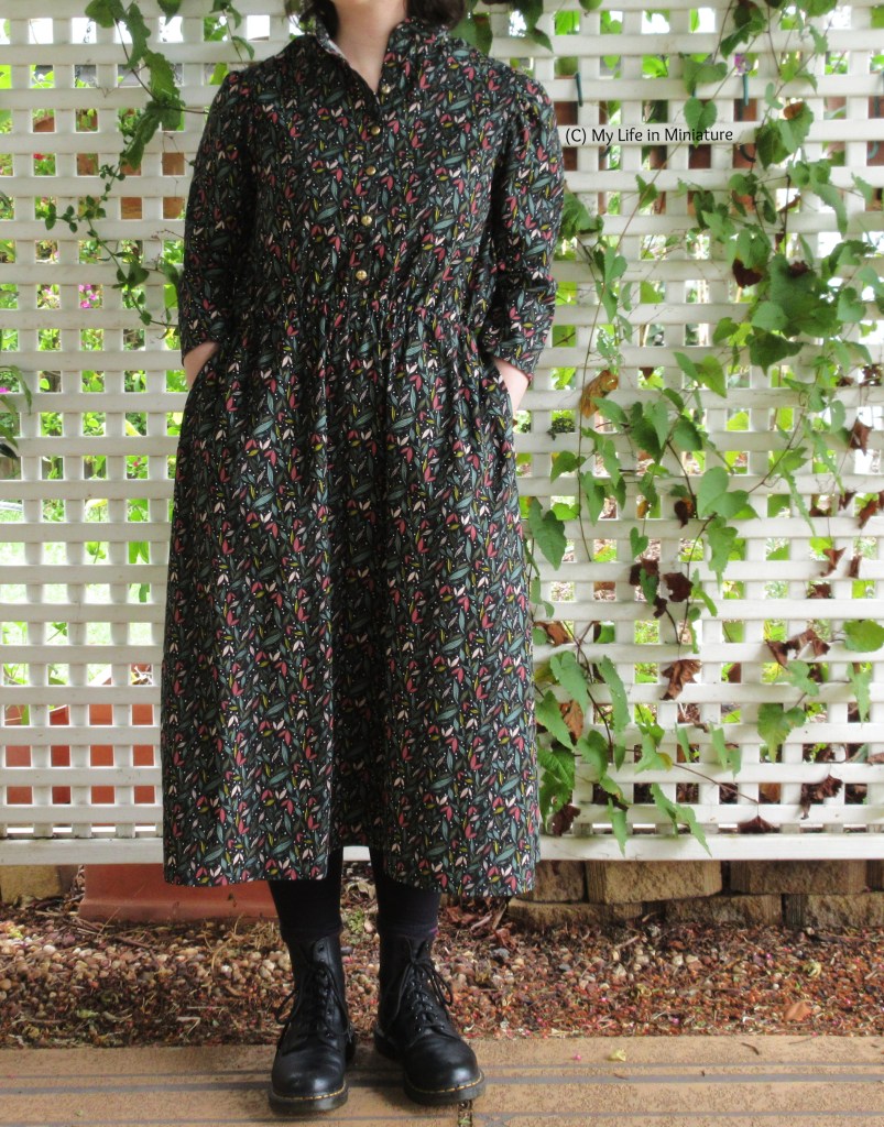The author poses in front of the lattice, with hands in the pockets of the dress.
