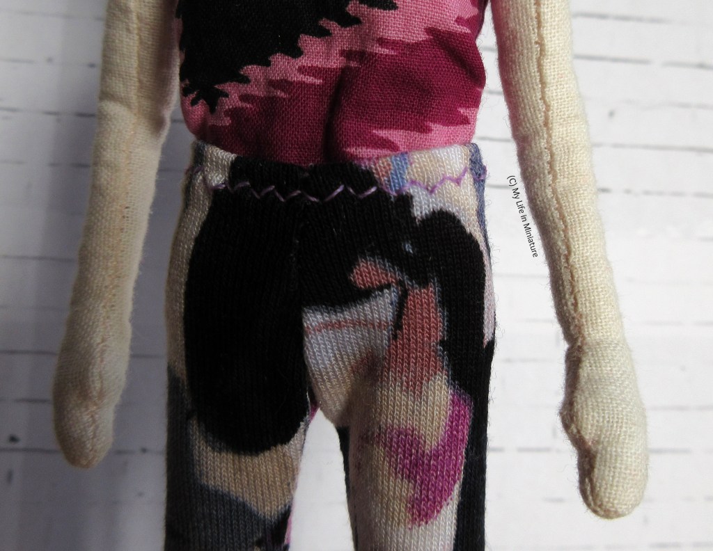 Close-up of the waistband of the leggings, which was covered in the previous image. It's stitched with a zizag stitch in pale purple thread. 