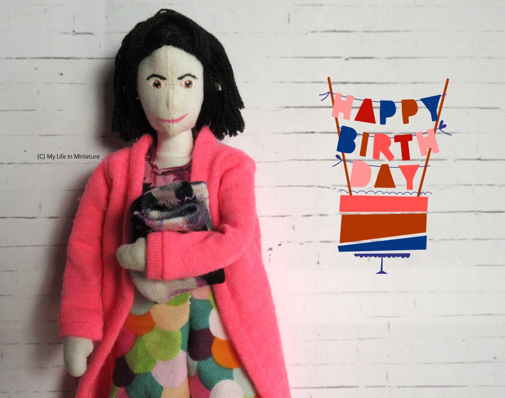 Thffany smiles at the camera, holding the folded leggings in her arms. A graphic hovering beside her says 'Happy Birthday', suspended as bunting over a cake. 