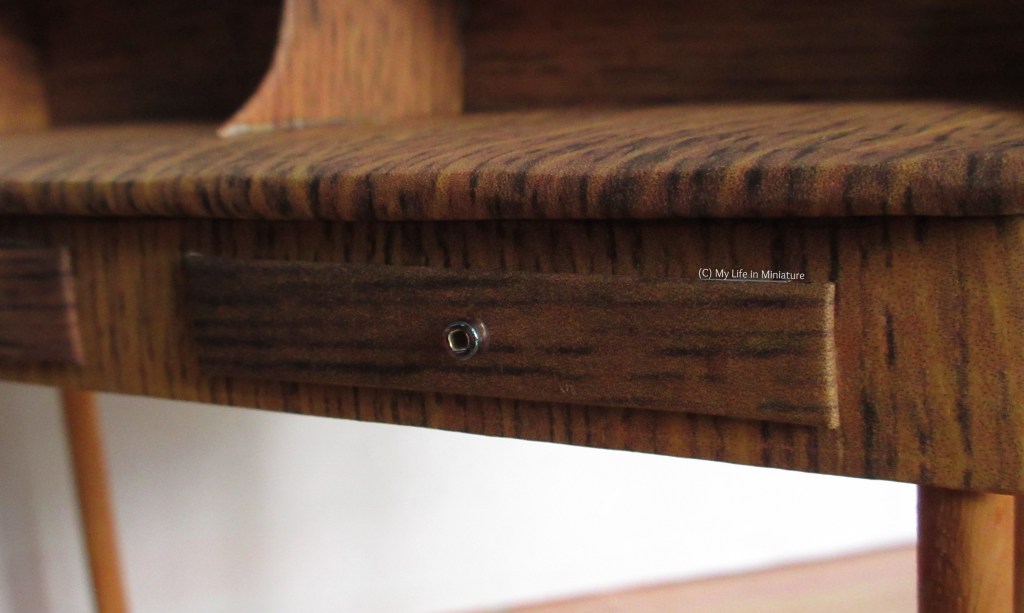 Close-up of the drawers underneath the work surface. Their handles are small beads, meant to imitate knobs. 