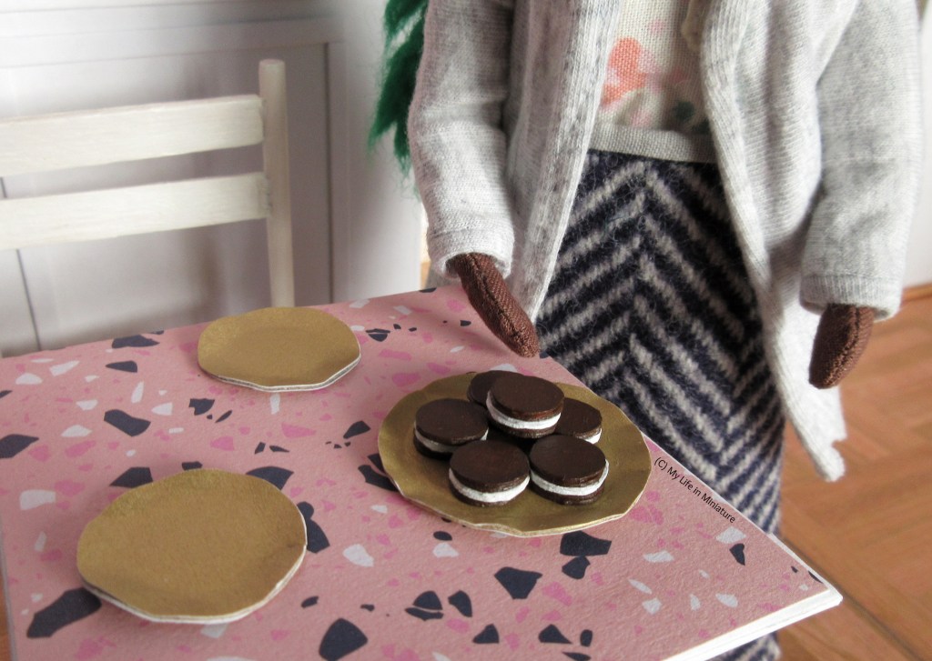 Close-up of the serving plate and the pastries on the table. There are six pastries stacked on the plate, with dark brown outsides and white insides. 