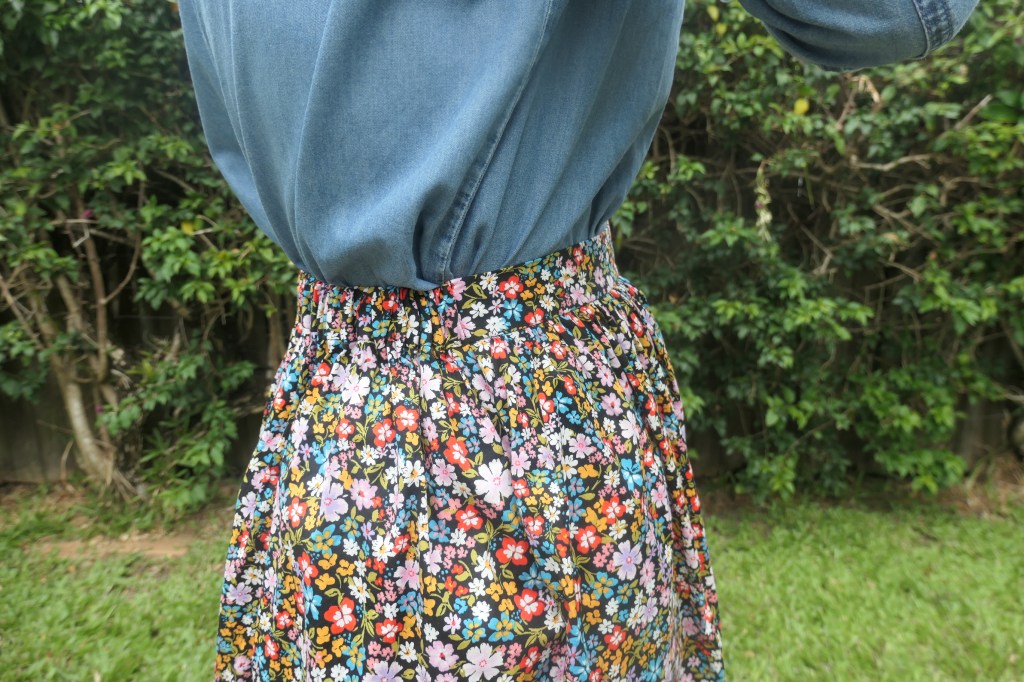 Another close-up of the floral skirt from the side. This shot focuses on the waistband, which is flat at the front and elasticated at the back. 