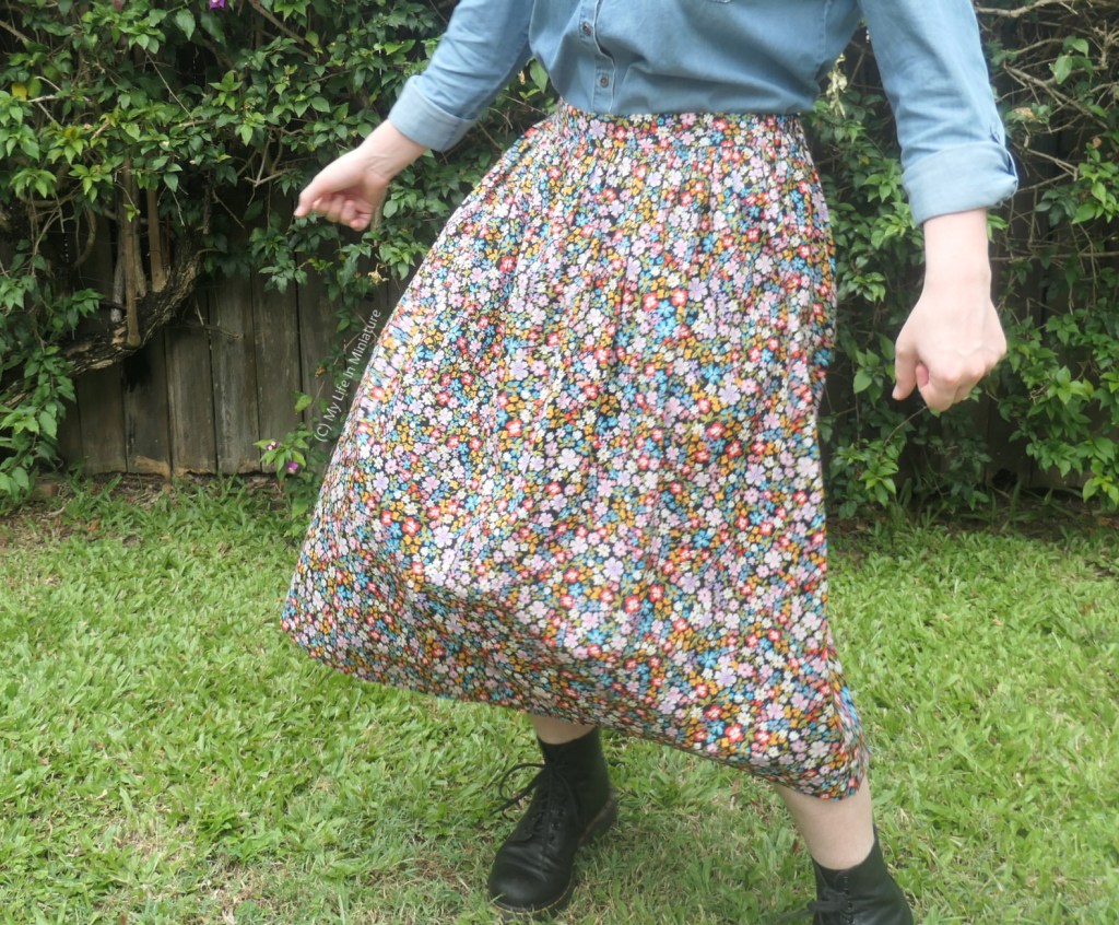 The author twirls in front of the hedge, trying to get the floral skirt to flare out with the momentum. 