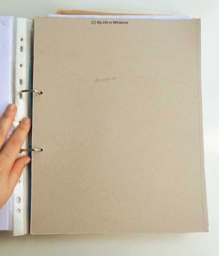 A cardboard section divider inside the binder. In the centre in pencil is written 'Accessories', and there is a line down the side, quite close to the external edge.