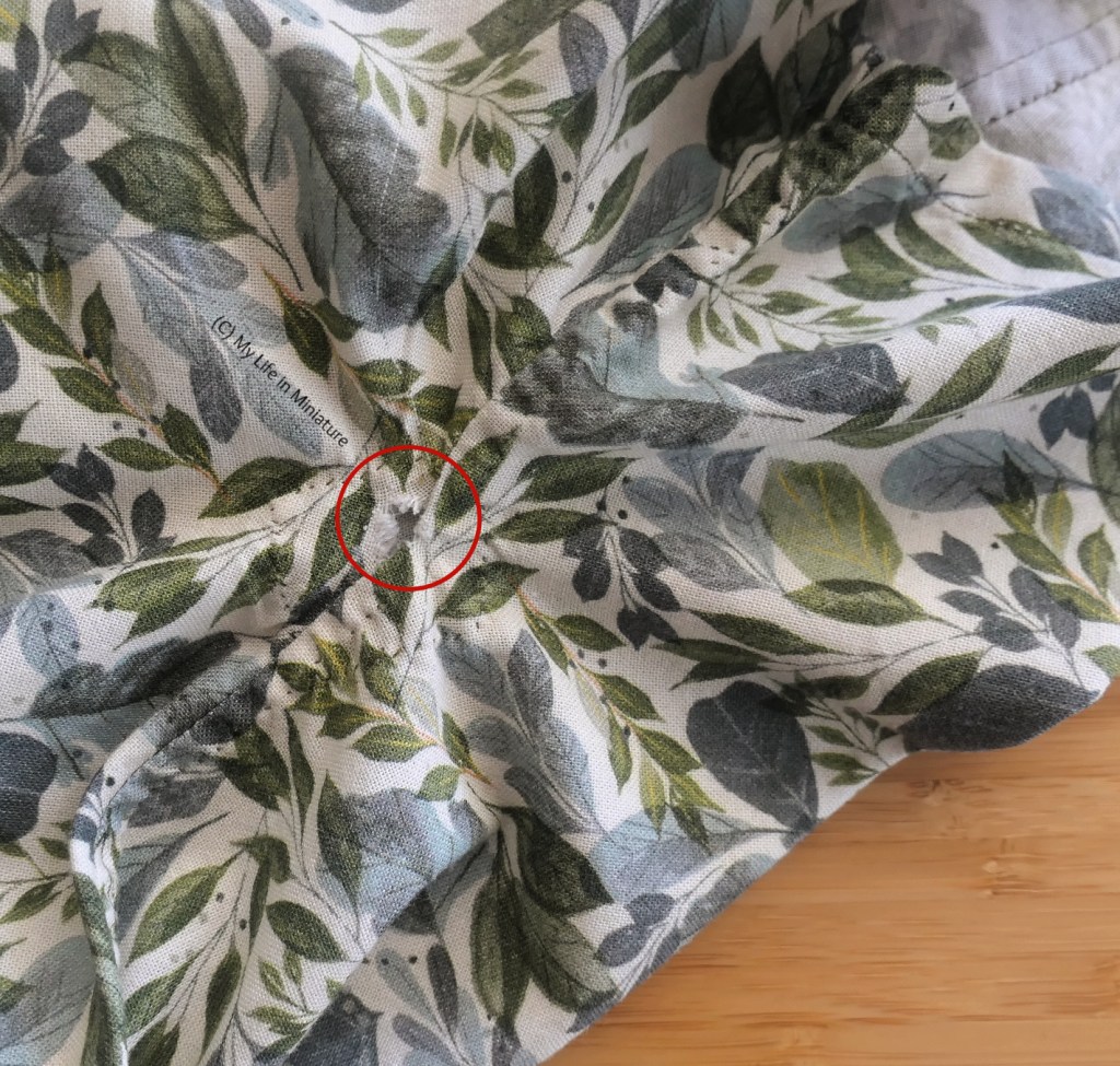 The side seam of the leafy shirt is as flat as it can get, especially around the underarm join. A red circle highlights the fraying underarm corner. 