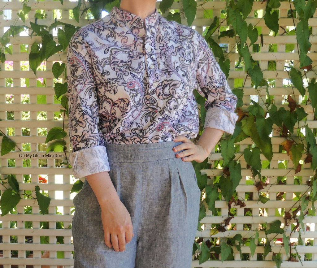 The author stands in the same place and wears the same outfit as the first image, photographed from neck to thighs. The sleeves are rolled up to about her elbows, and she has one hand on her hip and the other hanging in front of her. The wrong side of the fabric is a lot paler than the right side, making the rolled-up sleeves quite obvious.