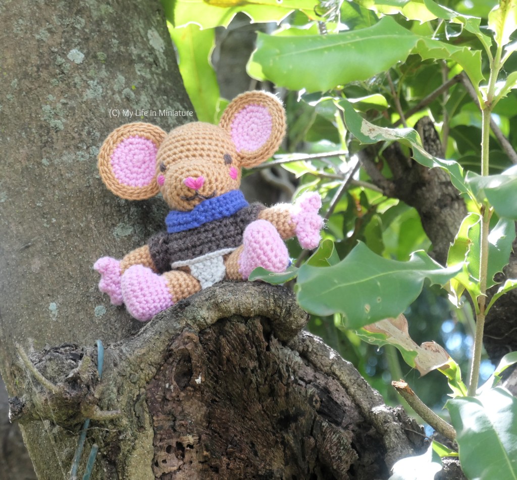 Lewt sits in a tree, perched on the remains of a cut-off branch. He leans back against the trunk of the tree. He is wearing his cloak, but doesn't have the staff. 