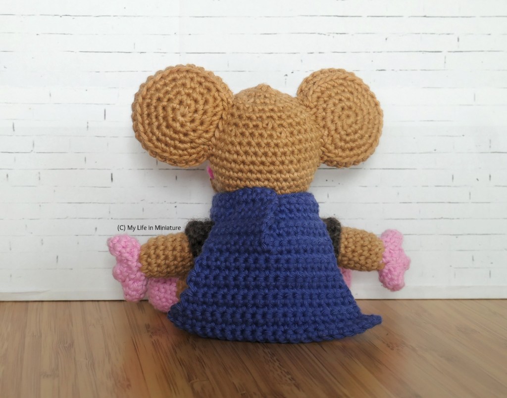 Back view of Lewt, against a white brick background. His cloak is most of what's visible, and is partially slit at centre back. The backs of his ears are completely brown. 