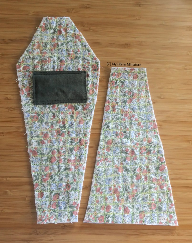 The two lighter green shapes are laid flat on a wood surface. They have been quilted in a grid pattern, and the coffin-shape has a dark green rectangle on it.