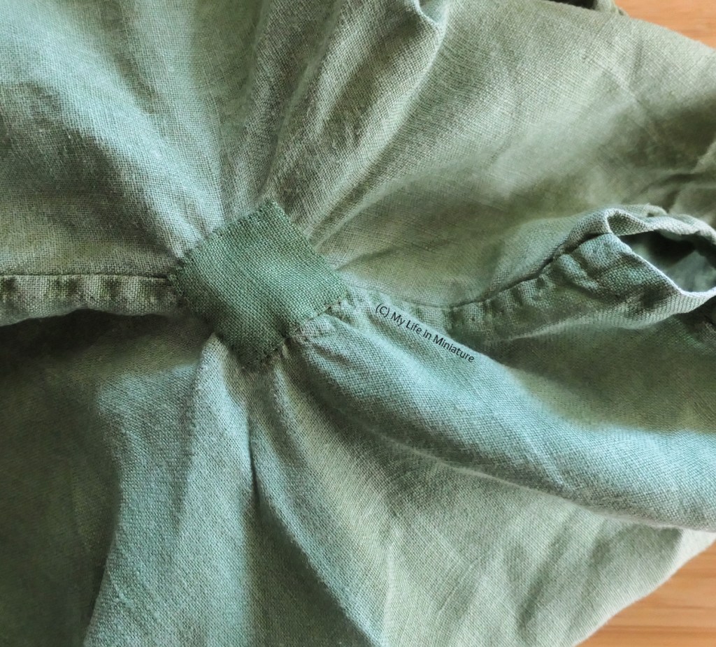Another close-up of the underarm of the author's green shirt. It has now been patched with a small square of linen in the same shade of green.